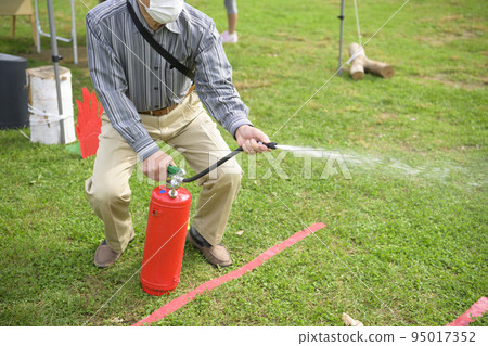 在防災活動中參加滅火器演習的男子 95017352