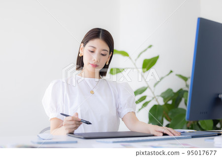 A woman working at a business desk A woman working at a business desk 95017677