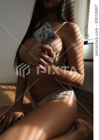 Sexy woman with condom in the room. Sexy woman with condom in the room. 95018007