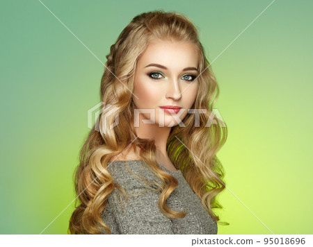 Blonde girl with long and shiny curly hair 95018696