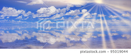 Sun rays shining into the Mirror Lake Uyuni salt lake 95019044