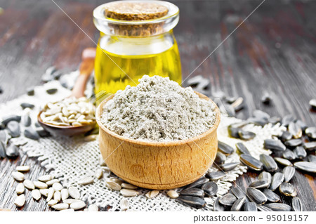 Flour sunflower in bowl on wooden board 95019157