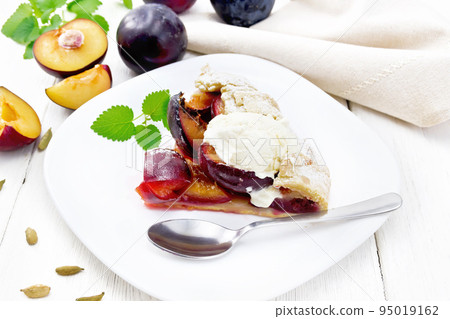 Galeta with plums in plate on wooden board Galeta with plums in plate on wooden board 95019162