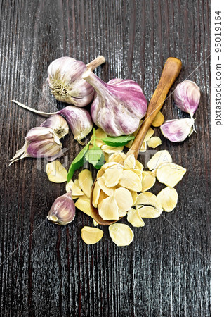 Garlic dried in spoon on dark board top Garlic dried in spoon on dark board top 95019164