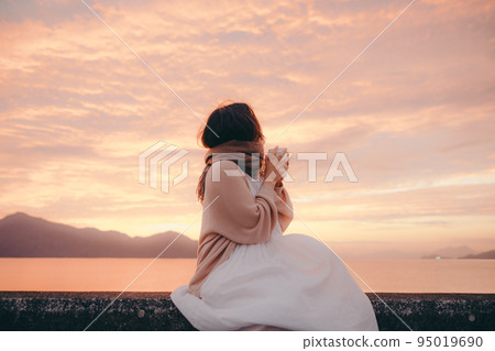 Photo of a woman with a beautiful sunrise 95019690