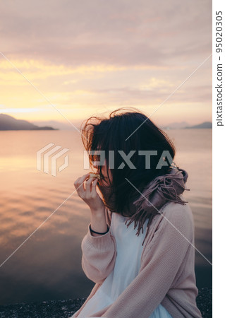 一個女人在美麗的日出中吃麵包的照片 一個女人在美麗的日出中吃麵包的照片 95020305