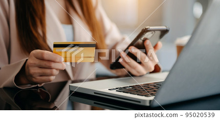 businesswoman hand using smart phone, tablet payments and holding credit card online shopping, omni channel businesswoman hand using smart phone, tablet payments and holding credit card online shopping, omni channel 95020539