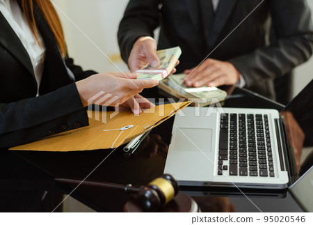 justice and law concept.passing bribe money in the envelop at lawyer office.. justice and law concept.passing bribe money in the envelop at lawyer office.. 95020546