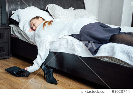 Job burnout, chronic workplace stress, exhaustion. Tired overworked businesswoman stressed young woman lying on the bed after work Job burnout, chronic workplace stress, exhaustion. Tired overworked businesswoman stressed young woman lying on the bed after work 95020744