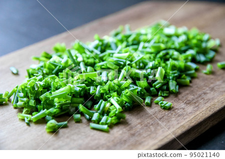 Fresh cut chives on a cutting board 95021140