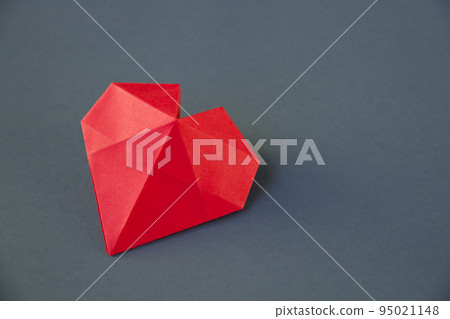 Red paper heart origami isolated on a grey background Red paper heart origami isolated on a grey background 95021148