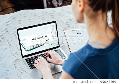 Job Search Career Recruitment Hiring Website Concept. Young woman in home browsing work opportunities online using job search web sites and applications Job Search Career Recruitment Hiring Website Concept. Young woman in home browsing work opportunities online using job search web sites and applications 95021169