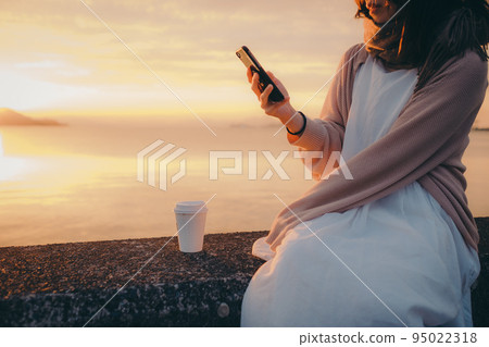 Photo of a woman with a beautiful sunrise Photo of a woman with a beautiful sunrise 95022318