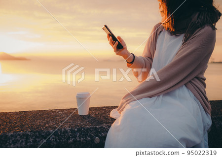 Photo of a woman with a beautiful sunrise Photo of a woman with a beautiful sunrise 95022319