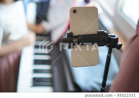 Elementary school girl giving online piano lessons Elementary school girl giving online piano lessons 95022331