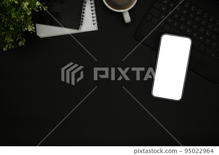 Mock up mobile phone with empty screen, coffee cup and notebook on black background. Top view with copy space Mock up mobile phone with empty screen, coffee cup and notebook on black background. Top view with copy space 95022964