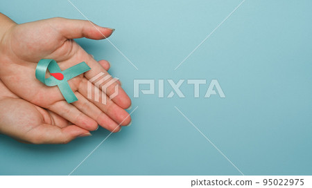 Blue ribbon with a drop of blood in a circle symbol of diabetes day in woman hands. World diabetes day, Copy space Blue ribbon with a drop of blood in a circle symbol of diabetes day in woman hands. World diabetes day, Copy space 95022975