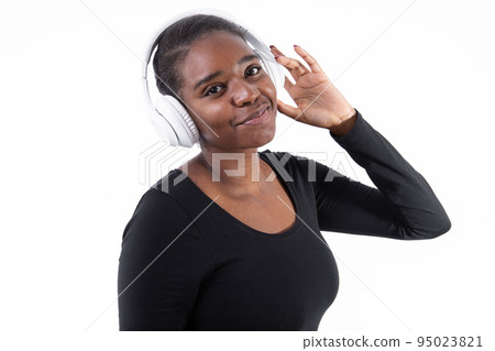 Portrait of positive woman listening to music in headphones Portrait of positive woman listening to music in headphones 95023821