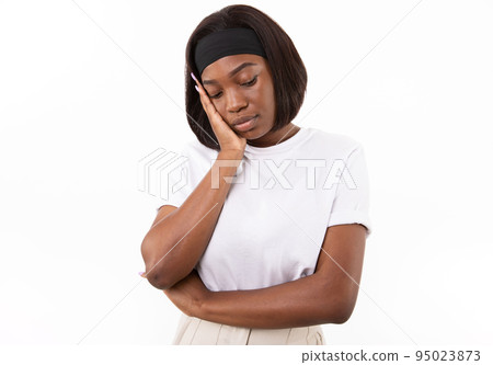 Portrait of bored young woman standing leaning head on hand Portrait of bored young woman standing leaning head on hand 95023873