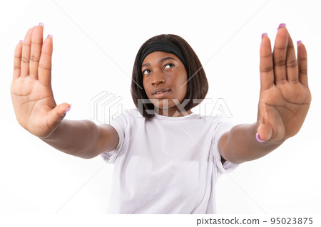 Portrait of smiling young woman making stop or frame gesture Portrait of smiling young woman making stop or frame gesture 95023875