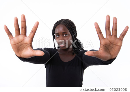 Portrait of smiling young woman making stop gesture 95023908