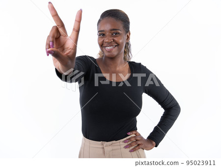 Portrait of cheerful young woman making rock gesture Portrait of cheerful young woman making rock gesture 95023911