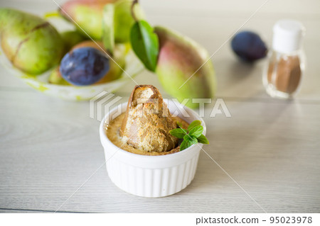 pear baked in curd dough in a small ceramic form 95023978