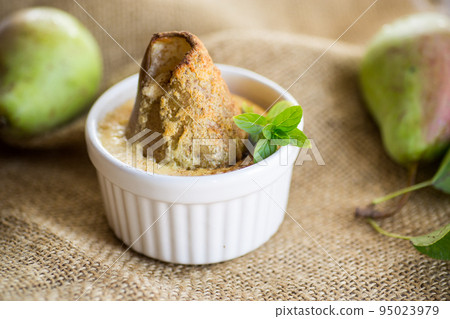 pear baked in curd dough in a small ceramic form 95023979