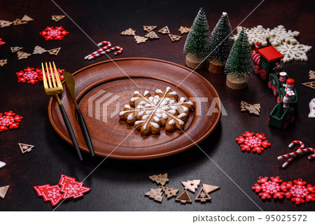 Christmas decoration elements as well as gingerbread on a brown concrete background Christmas decoration elements as well as gingerbread on a brown concrete background 95025572