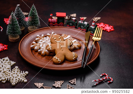 Christmas decoration elements as well as gingerbread on a brown concrete background 95025582