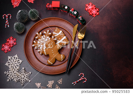 Christmas decoration elements as well as gingerbread on a brown concrete background Christmas decoration elements as well as gingerbread on a brown concrete background 95025583