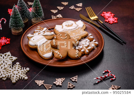 Christmas decoration elements as well as gingerbread on a brown concrete background Christmas decoration elements as well as gingerbread on a brown concrete background 95025584