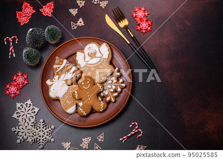 Christmas decoration elements as well as gingerbread on a brown concrete background Christmas decoration elements as well as gingerbread on a brown concrete background 95025585