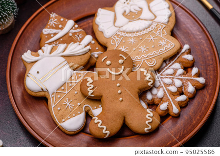Christmas decoration elements as well as gingerbread on a brown concrete background Christmas decoration elements as well as gingerbread on a brown concrete background 95025586