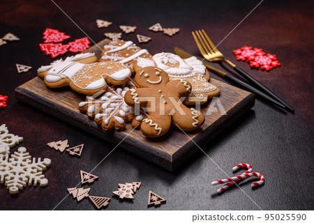 Christmas decoration elements as well as gingerbread on a brown concrete background Christmas decoration elements as well as gingerbread on a brown concrete background 95025590