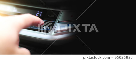 The driver hand is pressing the on-off button of the car air conditioner in the car The driver hand is pressing the on-off button of the car air conditioner in the car 95025983