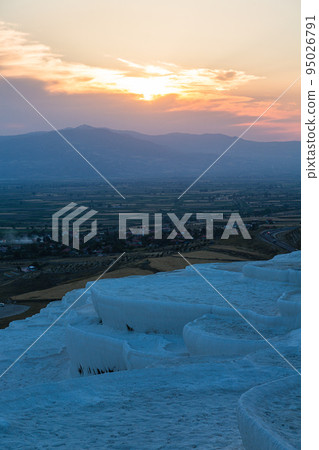 The travertine terraces of Hierapolis Pamukkale, Turkey, and the sun setting at sunset and the scenery seen from the travertine terraces The travertine terraces of Hierapolis Pamukkale, Turkey, and the sun setting at sunset and the scenery seen from the travertine terraces 95026791