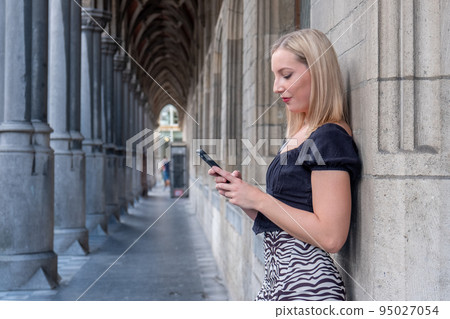 Happy blonde millennial girl in trendy clothes laughing on urban setting during sunny day, positive Happy blonde millennial girl in trendy clothes laughing on urban setting during sunny day, positive 95027054