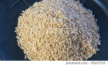 Brown rice served on a black plate on the table (overhead view) 95027543