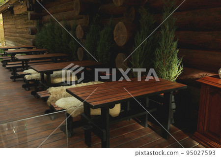 Cozy restaurant with outdoor tables in mountain resort Cozy restaurant with outdoor tables in mountain resort 95027593