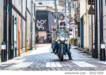 A female rider riding a large American motorcycle to shop at Yokohama Motomachi Shopping Street 95027809