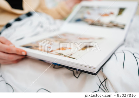 Selective focus and blurry photos. a woman holds a photo book. 95027810