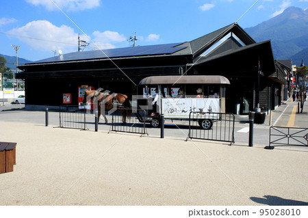Townscape in front of Yufuin Station in Oita Prefecture Scenery of horse-drawn carriages passing by 95028010