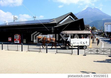 Townscape in front of Yufuin Station in Oita Prefecture Scenery of horse-drawn carriages passing by 95028011