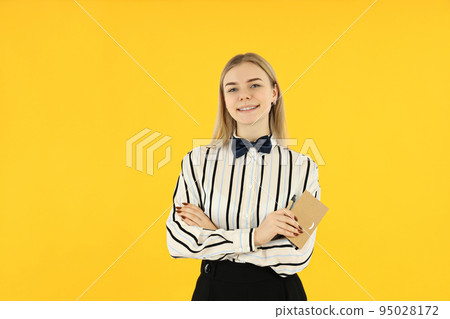 Concept of occupation, young female waiter on yellow background 95028172
