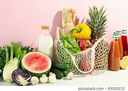 Different food and drinks on white table against pink background Different food and drinks on white table against pink background 95028212