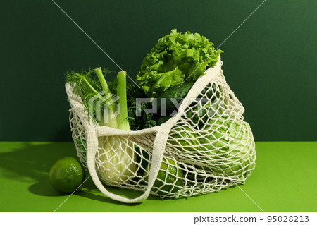 String bag with vegetables and fruits on two tone background String bag with vegetables and fruits on two tone background 95028213