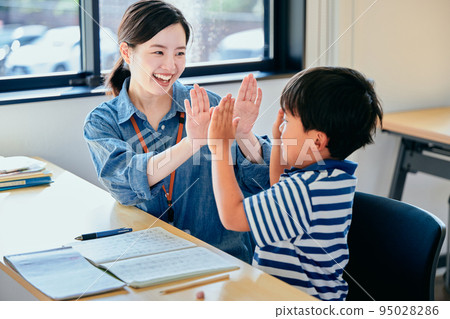 High touch cram school teacher and elementary school boy 95028286