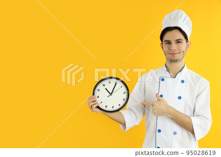Concept of cooking, young man chef on yellow background 95028619