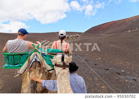 Riding camels in National Park of Timanfaya - Lanzarote Spain Riding camels in National Park of Timanfaya - Lanzarote Spain 95030702